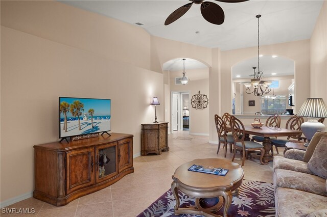 living room with light tile patterned floors and ceiling fan with notable chandelier