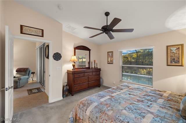 bedroom featuring multiple windows, light colored carpet, and ceiling fan