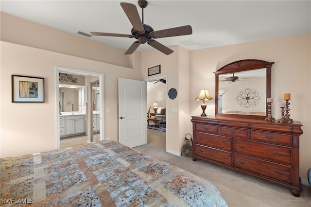 bedroom featuring ceiling fan, light carpet, and ensuite bath