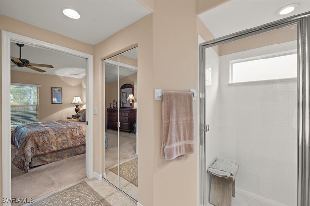 bathroom featuring ceiling fan, tile patterned floors, and a shower with door