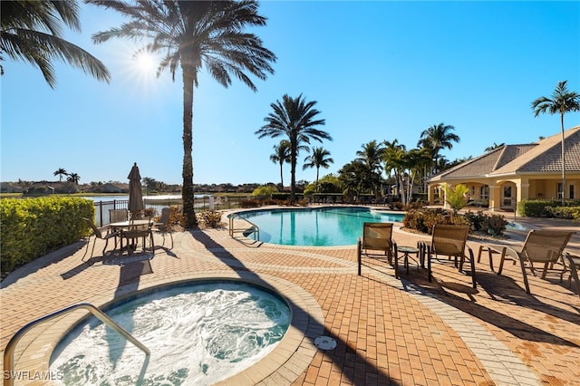 view of pool with a hot tub and a patio