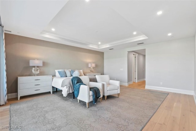 bedroom featuring visible vents, baseboards, wood finished floors, recessed lighting, and a tray ceiling
