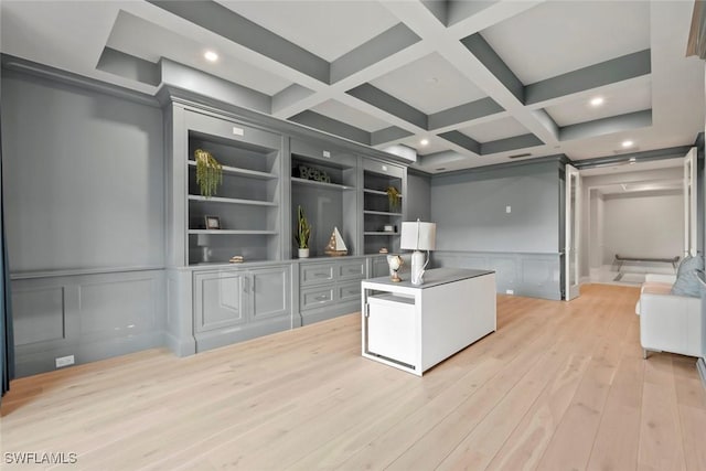unfurnished office featuring coffered ceiling, beamed ceiling, and light wood-type flooring