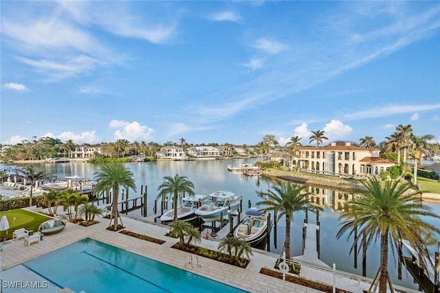 view of pool with a water view, boat lift, and a boat dock