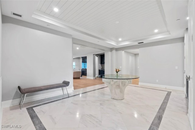 interior space featuring baseboards, visible vents, recessed lighting, and a raised ceiling