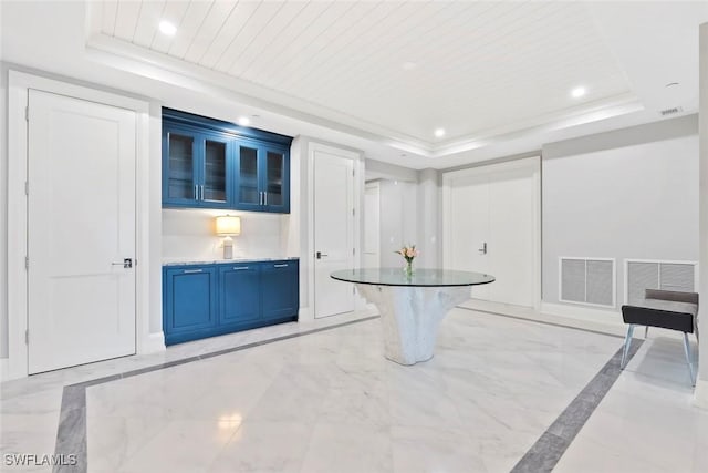 interior space with blue cabinetry, a raised ceiling, wood ceiling, and visible vents