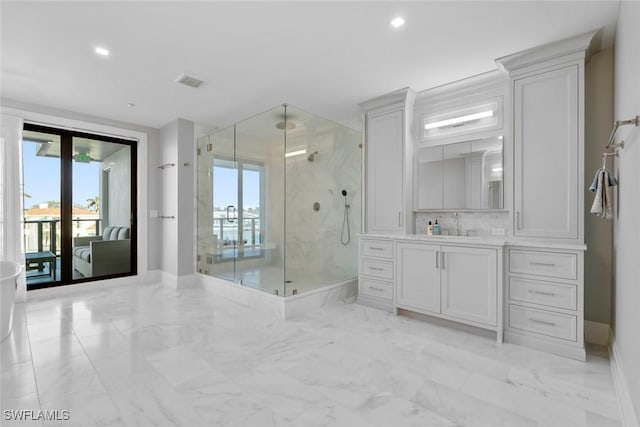 full bathroom featuring visible vents, baseboards, marble finish floor, a marble finish shower, and vanity