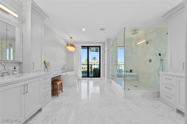bathroom with vanity, a marble finish shower, marble finish floor, a freestanding bath, and recessed lighting
