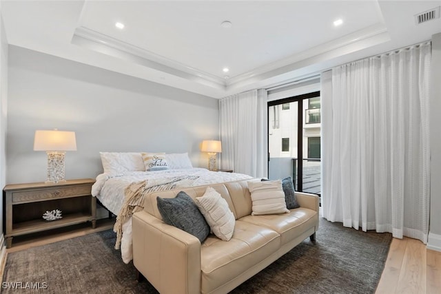 bedroom featuring visible vents, wood finished floors, and a raised ceiling