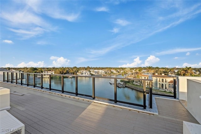 dock area with a balcony and a water view