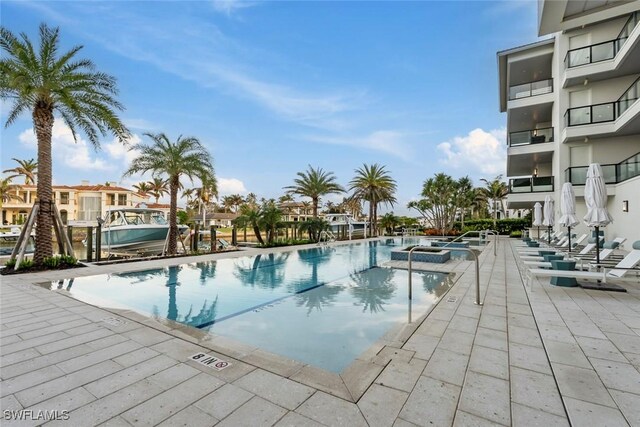 community pool with a jacuzzi and a patio area