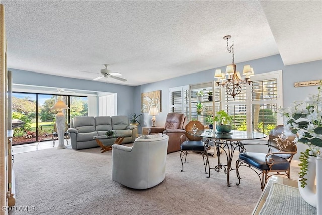 carpeted living room with ceiling fan with notable chandelier and a textured ceiling