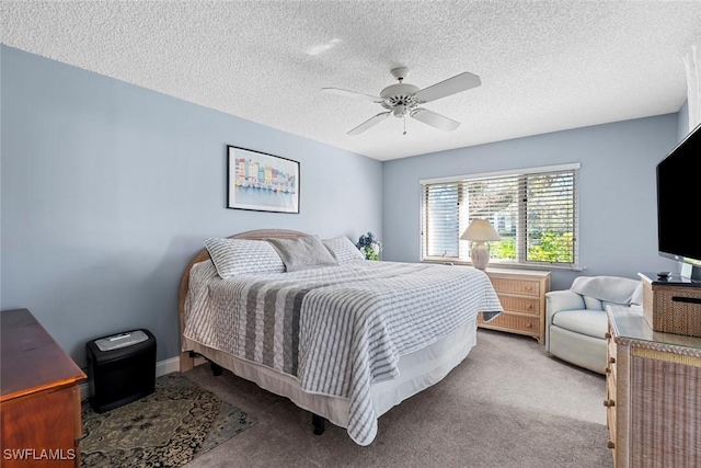 carpeted bedroom featuring ceiling fan and a textured ceiling