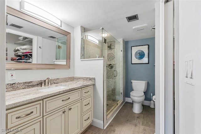 bathroom with walk in shower, vanity, toilet, and wood-type flooring