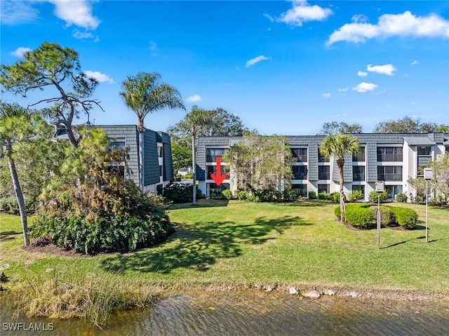 view of front of house with a front yard and a water view