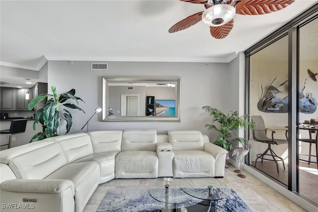 tiled living room with ceiling fan and ornamental molding