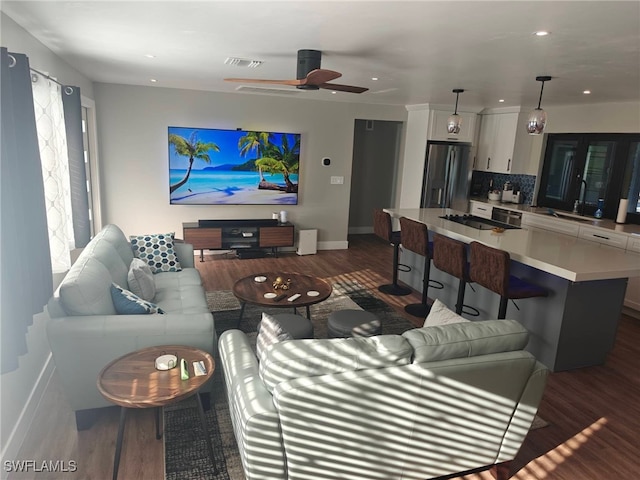 living room featuring dark wood-type flooring and ceiling fan