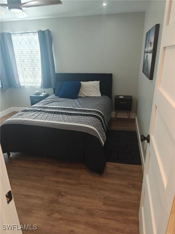 bedroom with dark hardwood / wood-style floors