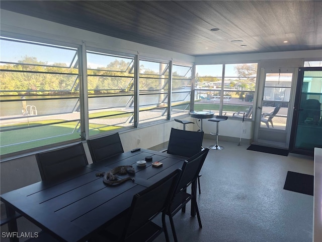 sunroom with a water view and wood ceiling