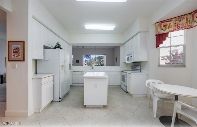 kitchen featuring white cabinetry, a kitchen island, plenty of natural light, and white appliances