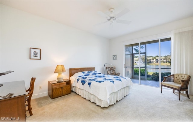 carpeted bedroom with a water view, access to exterior, and ceiling fan