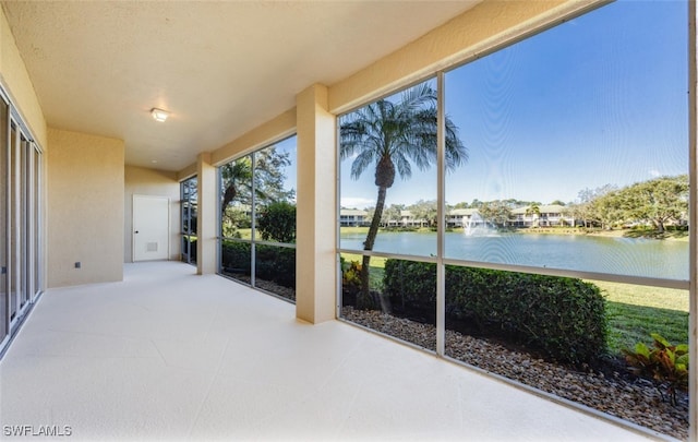 sunroom featuring a water view