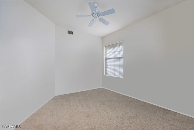 empty room featuring visible vents, baseboards, ceiling fan, and light colored carpet