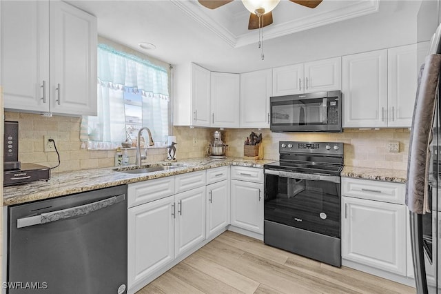 kitchen with ornamental molding, a ceiling fan, a sink, stainless steel appliances, and a raised ceiling