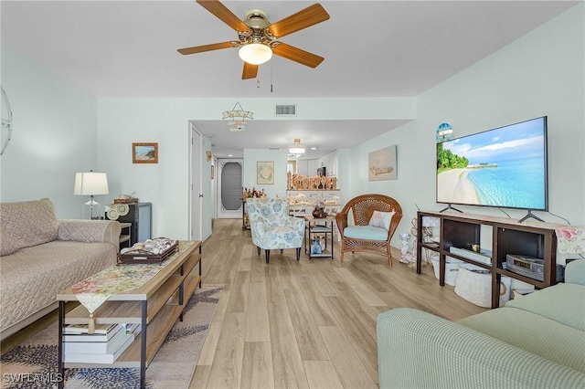 living room featuring ceiling fan and light hardwood / wood-style floors