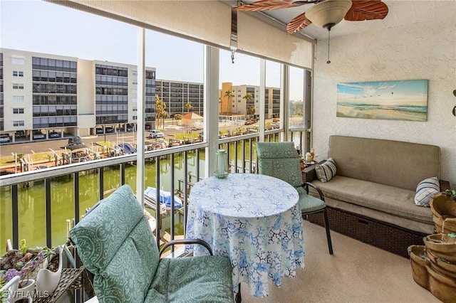 sunroom with a water view and ceiling fan