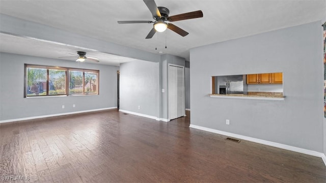 unfurnished living room featuring dark wood-style floors, visible vents, a ceiling fan, and baseboards