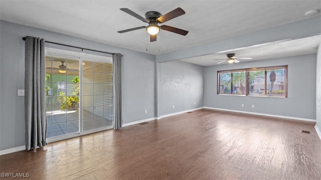 unfurnished room featuring wood finished floors, a ceiling fan, and baseboards