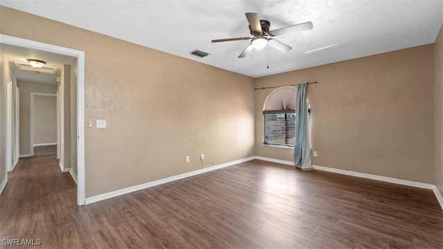 empty room with a ceiling fan, wood finished floors, visible vents, and baseboards