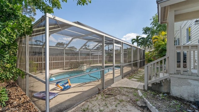 view of swimming pool featuring a lanai, a patio area, fence, and a fenced in pool