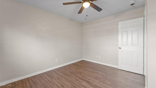 unfurnished room featuring ceiling fan, baseboards, and wood finished floors