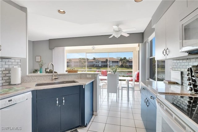 kitchen featuring blue cabinets, sink, tasteful backsplash, white appliances, and white cabinets