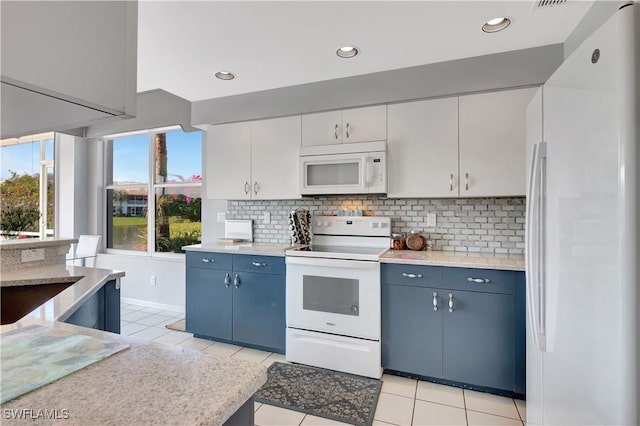 kitchen featuring backsplash, white appliances, blue cabinetry, and light tile patterned floors