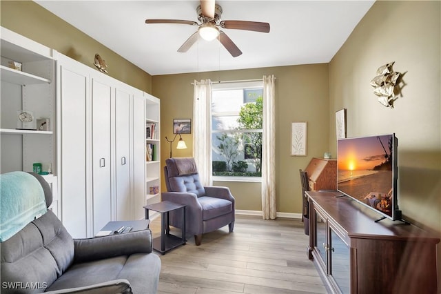 living area with ceiling fan and light hardwood / wood-style flooring