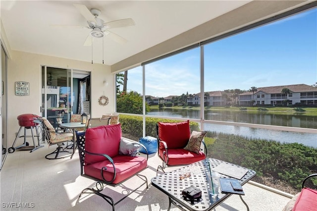 sunroom / solarium featuring ceiling fan and a water view