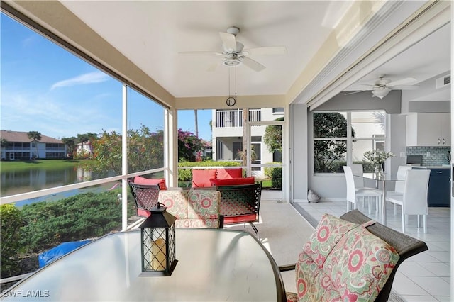 sunroom with a water view and ceiling fan