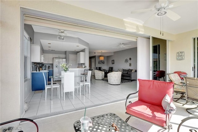 living room featuring light tile patterned floors and ceiling fan