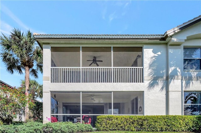 back of house featuring ceiling fan and a balcony