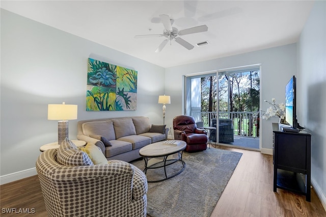 living room with visible vents, baseboards, a ceiling fan, and wood finished floors