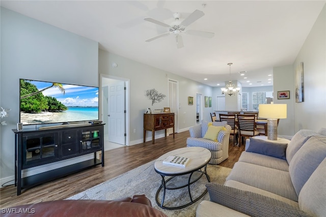 living room featuring wood-type flooring and ceiling fan with notable chandelier