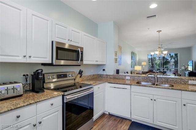 kitchen with sink, white cabinets, hanging light fixtures, kitchen peninsula, and stainless steel appliances