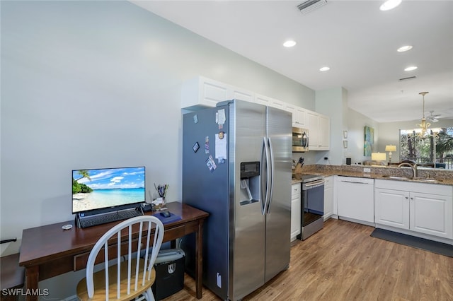 kitchen featuring sink, white cabinetry, light stone counters, light hardwood / wood-style flooring, and appliances with stainless steel finishes