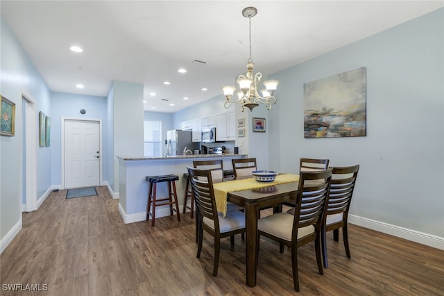 dining space featuring dark hardwood / wood-style flooring and a notable chandelier