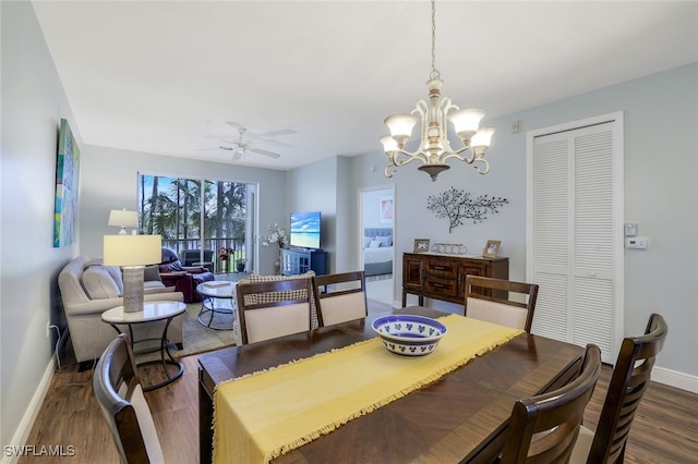 dining area featuring ceiling fan with notable chandelier and dark wood-type flooring