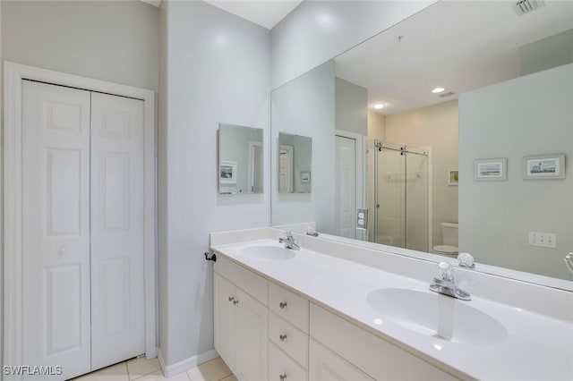 bathroom with walk in shower, tile patterned floors, vanity, and toilet