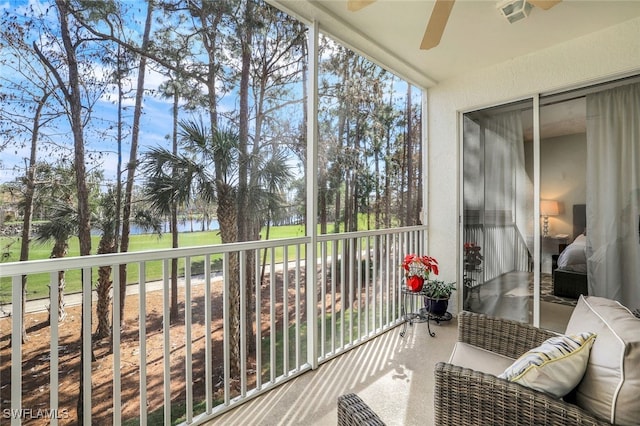 sunroom / solarium featuring a water view and ceiling fan